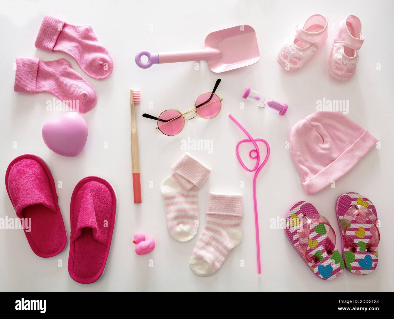 Bebé niña ducha plano concepto de la disposición. Ropa de color rosa recién nacido y accesorios sobre fondo blanco, vista superior. Foto de stock
