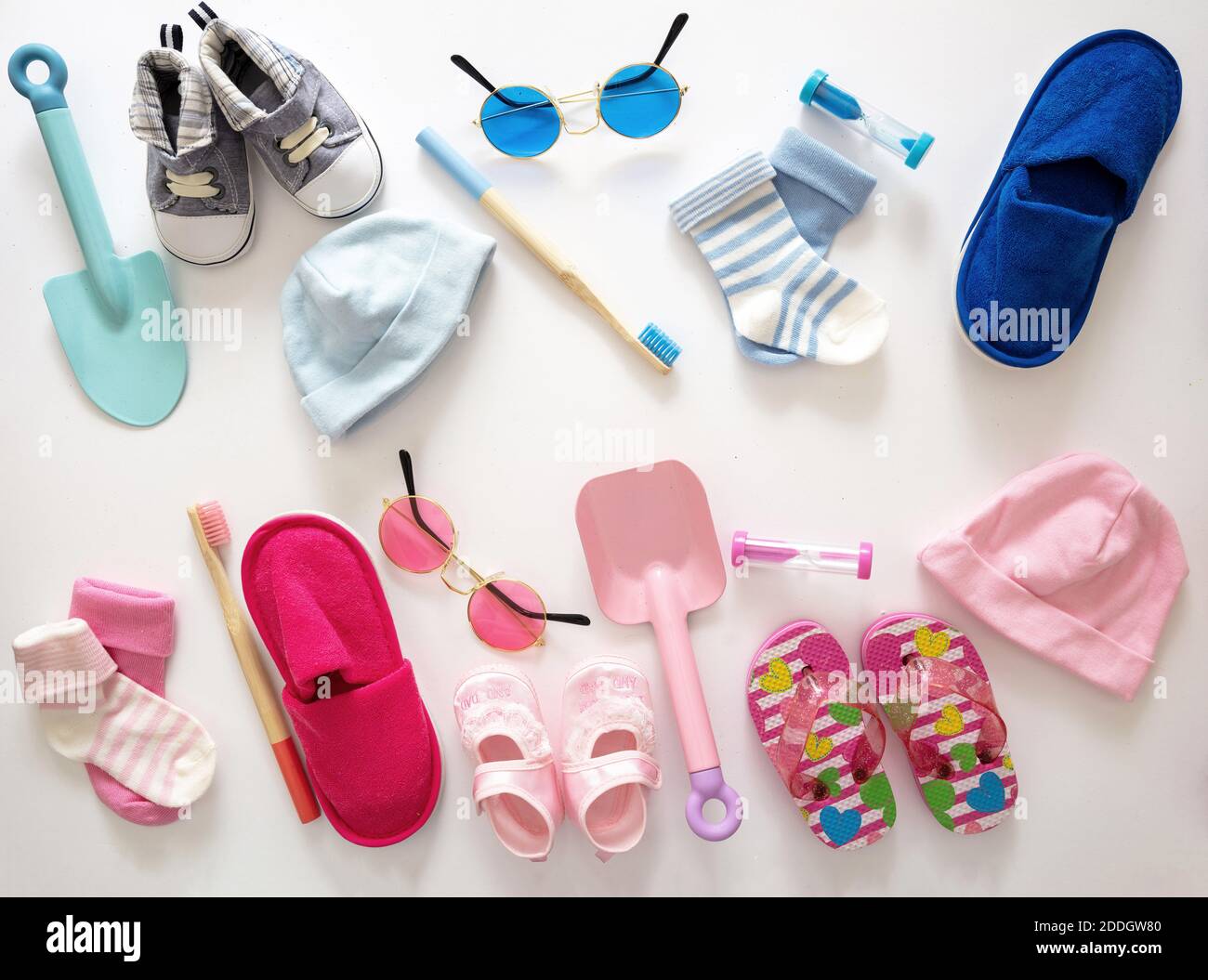 El concepto de cama plana para la ducha del bebé. Ropa y accesorios de color rosa pastel y azul recién nacido sobre fondo blanco, vista superior. Foto de stock