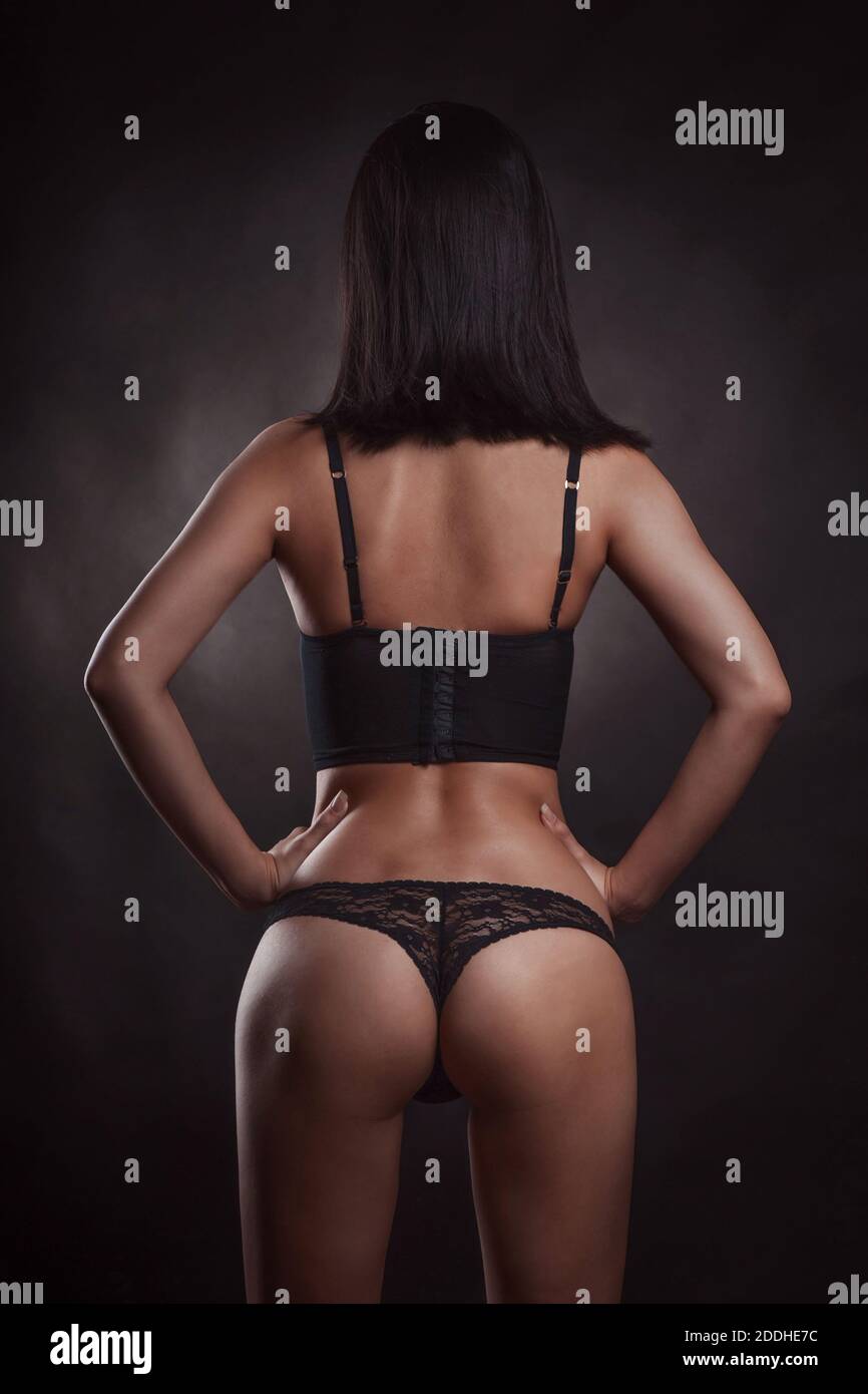 Espalda de mujer delgada en ropa interior negra en el estudio sobre fondo  oscuro Fotografía de stock - Alamy