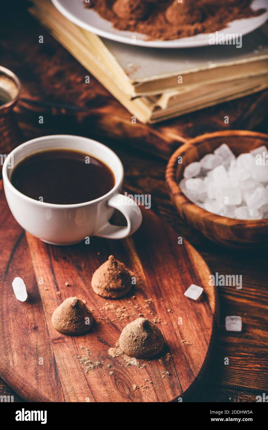 Trufas de chocolate recubiertas de cacao en polvo con café negro Foto de stock