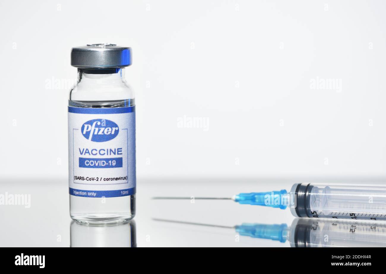 STARIY OSKOL, RUSIA - 23 DE NOVIEMBRE de 2020: Nueva vacuna Pfizer y jeringa sobre fondo blanco foto conceptual Foto de stock