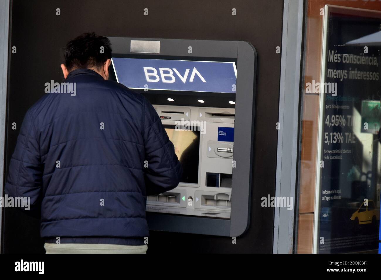 Un hombre retira dinero de un cajero automático del Banco BBVA en una oficina bancaria en Vendrell Tarragona.la fusión de BBVA (Banco Bilbao Vizcaya Argentaria) y Sabadell Bank crearía el segundo gigante bancario de casi 600,000 millones en el mercado español por volumen de activos, Solo detrás de la entidad que resultó de la fusión de CaixaBank y Bankia. Foto de stock