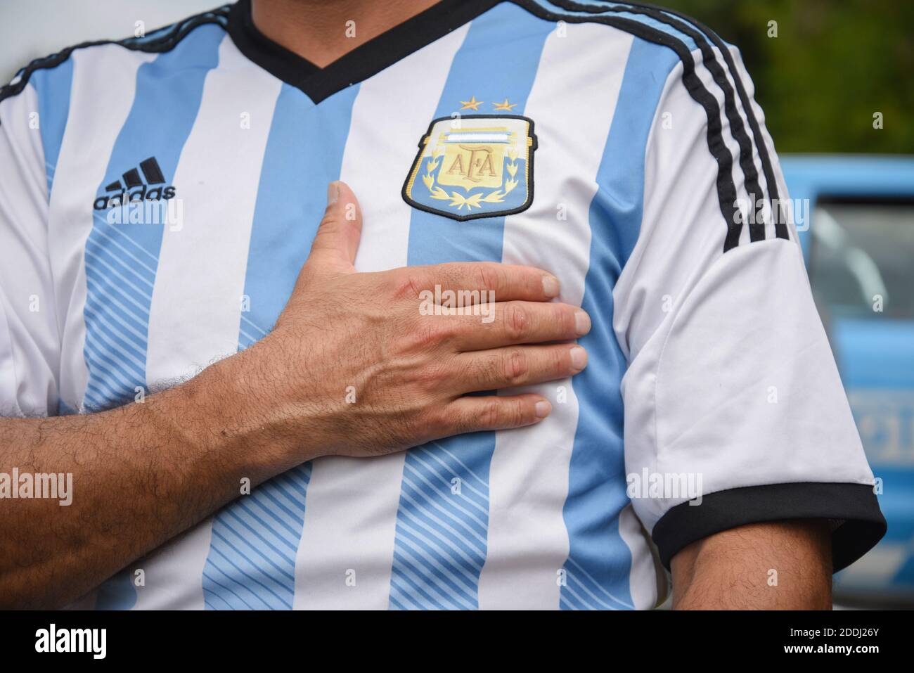 Buenos Aires, Argentina. 25 de noviembre de 2020. Un hombre vestido con una  camiseta del equipo nacional argentino y parado frente a la casa donde  murió Diego Maradona pone su mano en