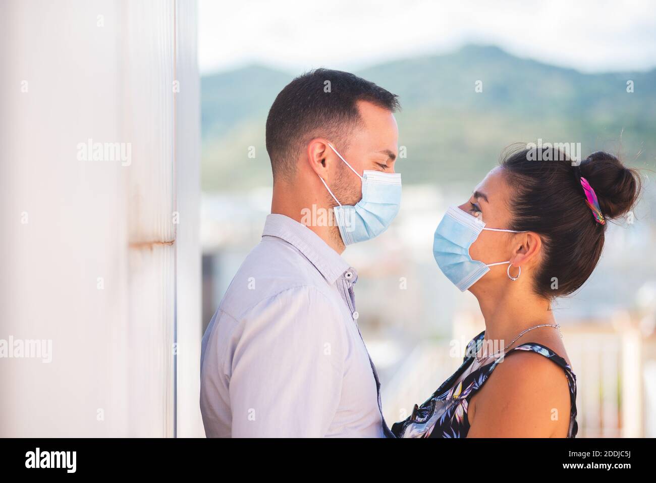Un hombre y una mujer mirando entre sí máscaras de protección contra coronavirus Foto de stock