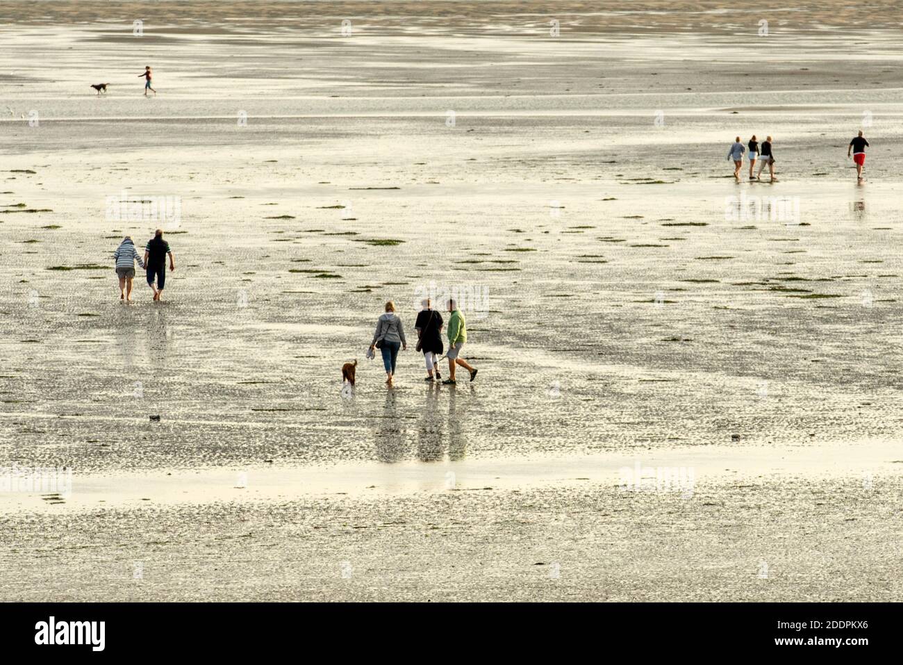 Gente de diferentes edades disfrutando de una tarde soleada en una playa de arena y en el mar en Hayling Island, Hampshire, Inglaterra, Reino Unido Foto de stock