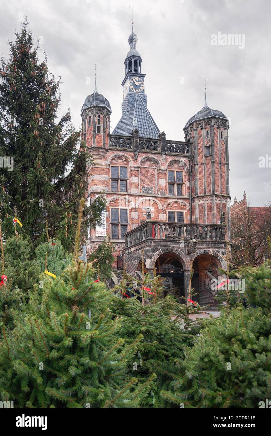 Deventer, países Bajos, 15 de diciembre de 2018: El museo de Waag en el casco antiguo de Deventer con la venta de árboles de Navidad en primer plano. Foto de stock