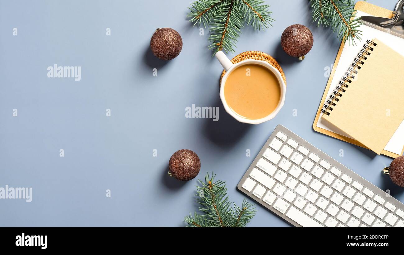 Mesa de escritorio con taza de café, teclado de ordenador, portátil,  portapapeles, ramas de pino y decoraciones navideñas. Plano, vista  superior. Wint Fotografía de stock - Alamy