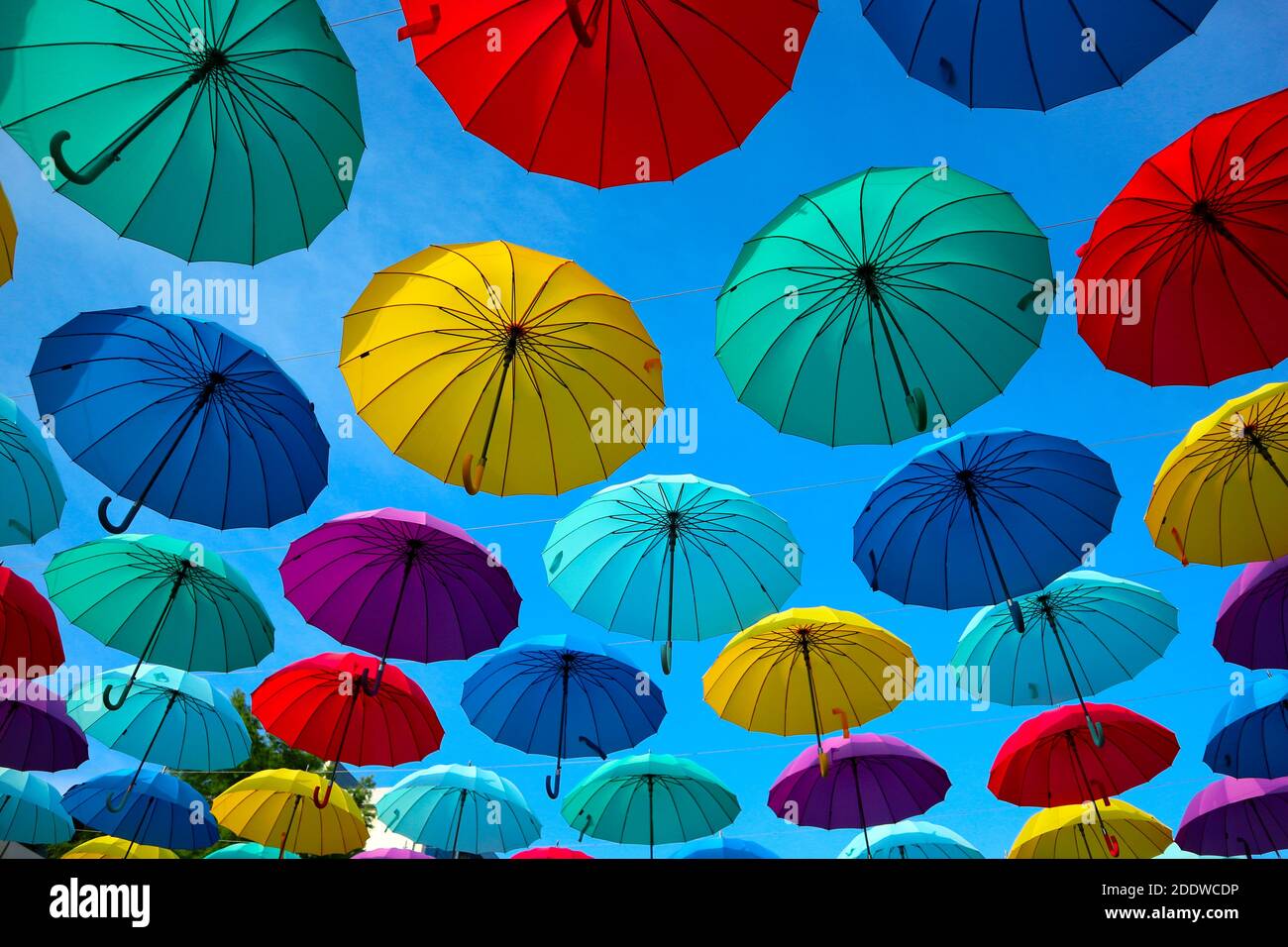 Paraguas de colores en el cielo. Protección contra el sol y la lluvia en la  calle Fotografía de stock - Alamy