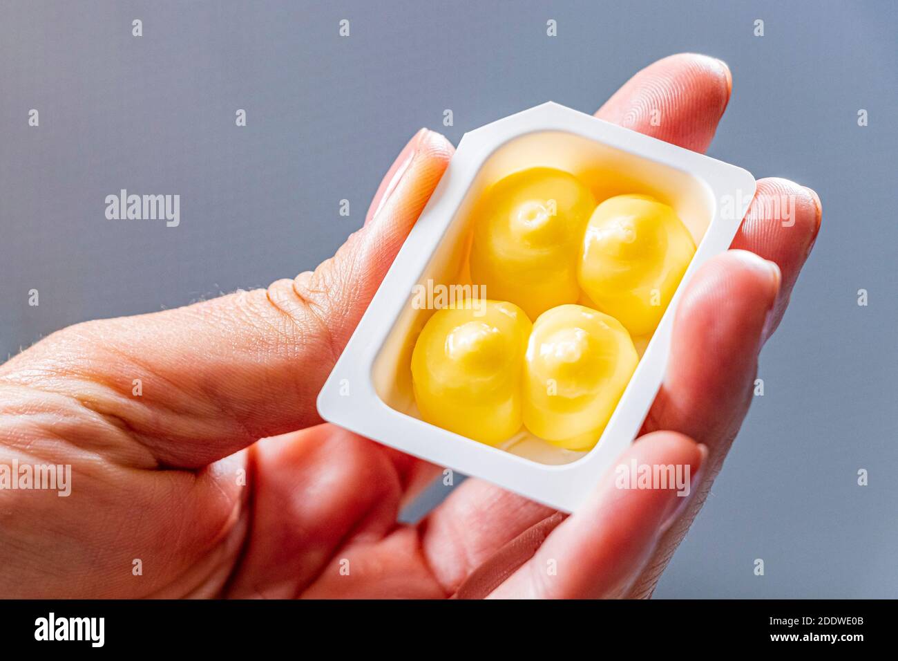 Un pequeño paquete de mantequilla en la mano de una mujer en el avión  Fotografía de stock - Alamy