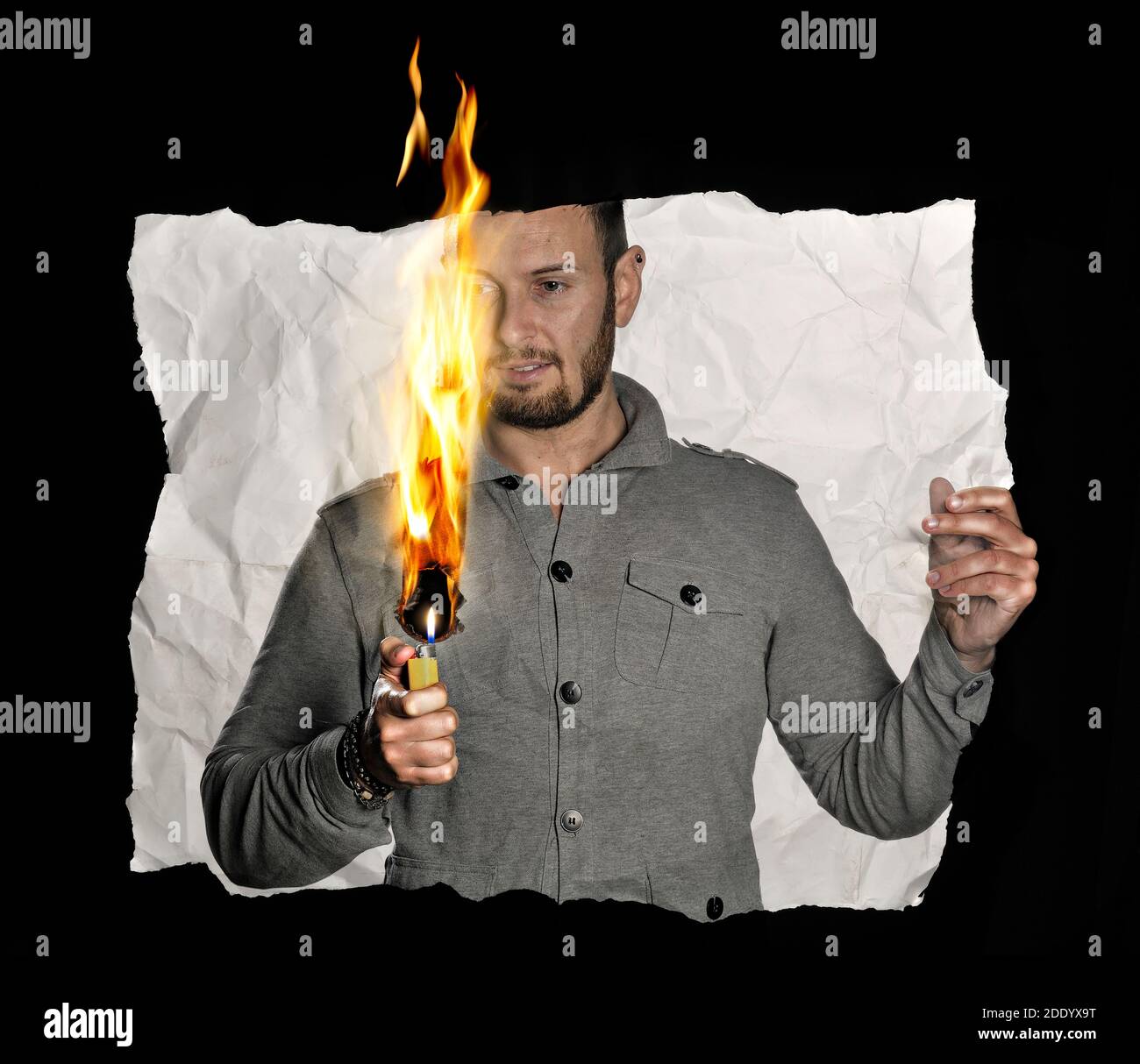 El hombre dentro de una fotografía con un encendedor quema la foto en la que está. Foto de stock