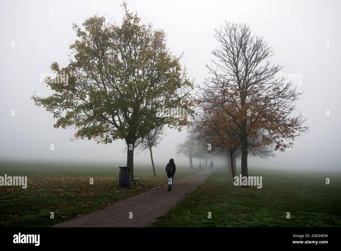 Victoria Park, Londres Noviembre de 2020 durante la pandemia de Covid-19 (Coronavirus). Neblina de la mañana. Caminante solitario Foto de stock