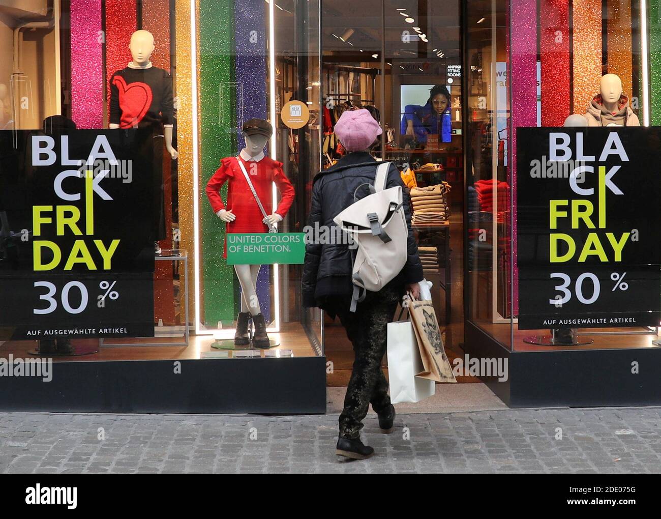 Los carteles que ofrecen un descuento especial en las ventas de Black Friday  se ven frente a una tienda de moda infantil de United Colors of Benetton,  mientras continúa la propagación de