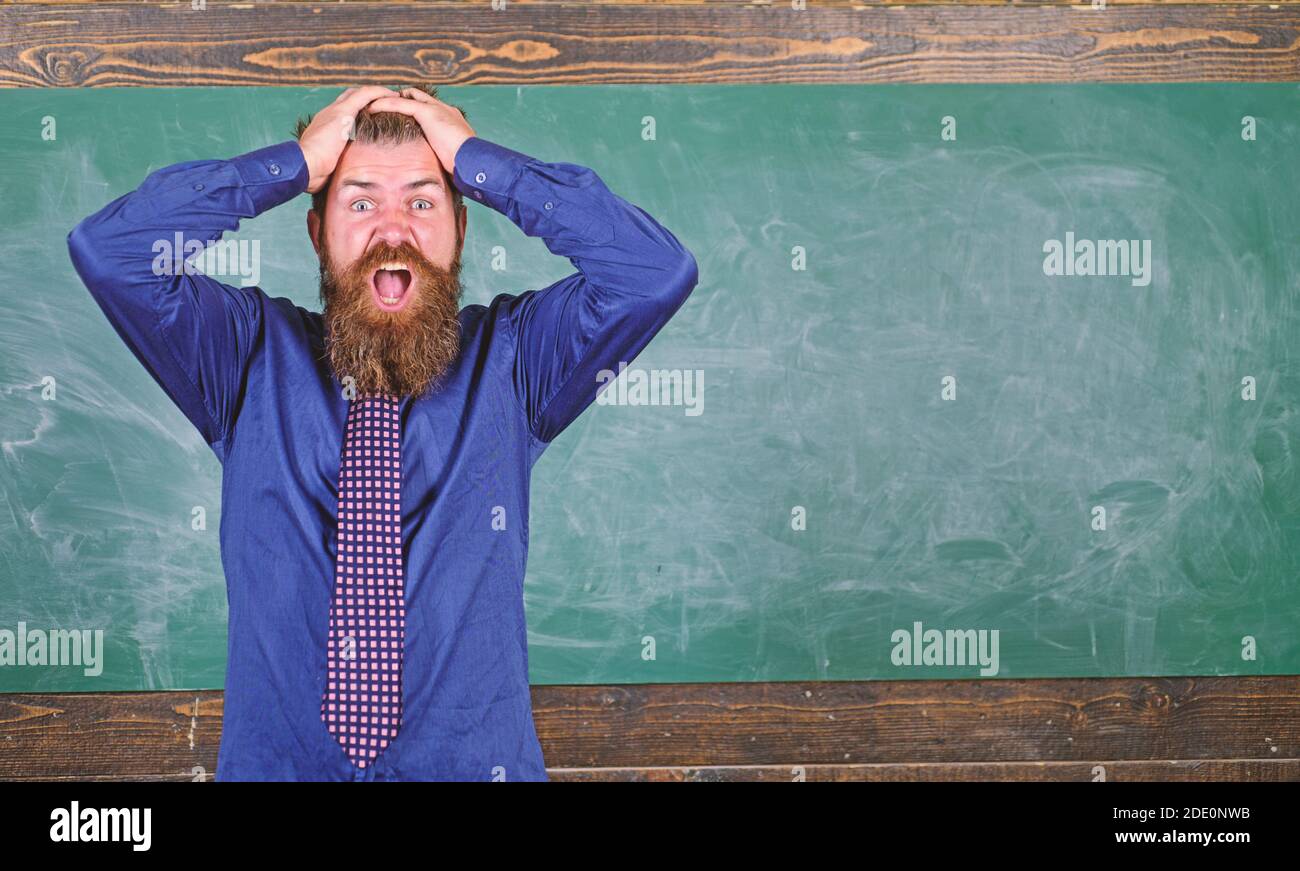 El hombre barbudo maestro o educador tienen fondo de la pizarra principal. Preste atención a su comportamiento y modales. Etiqueta de los maestros consejos profesionales de la educación moderna. El maestro se comporta de manera poco profesional. Foto de stock