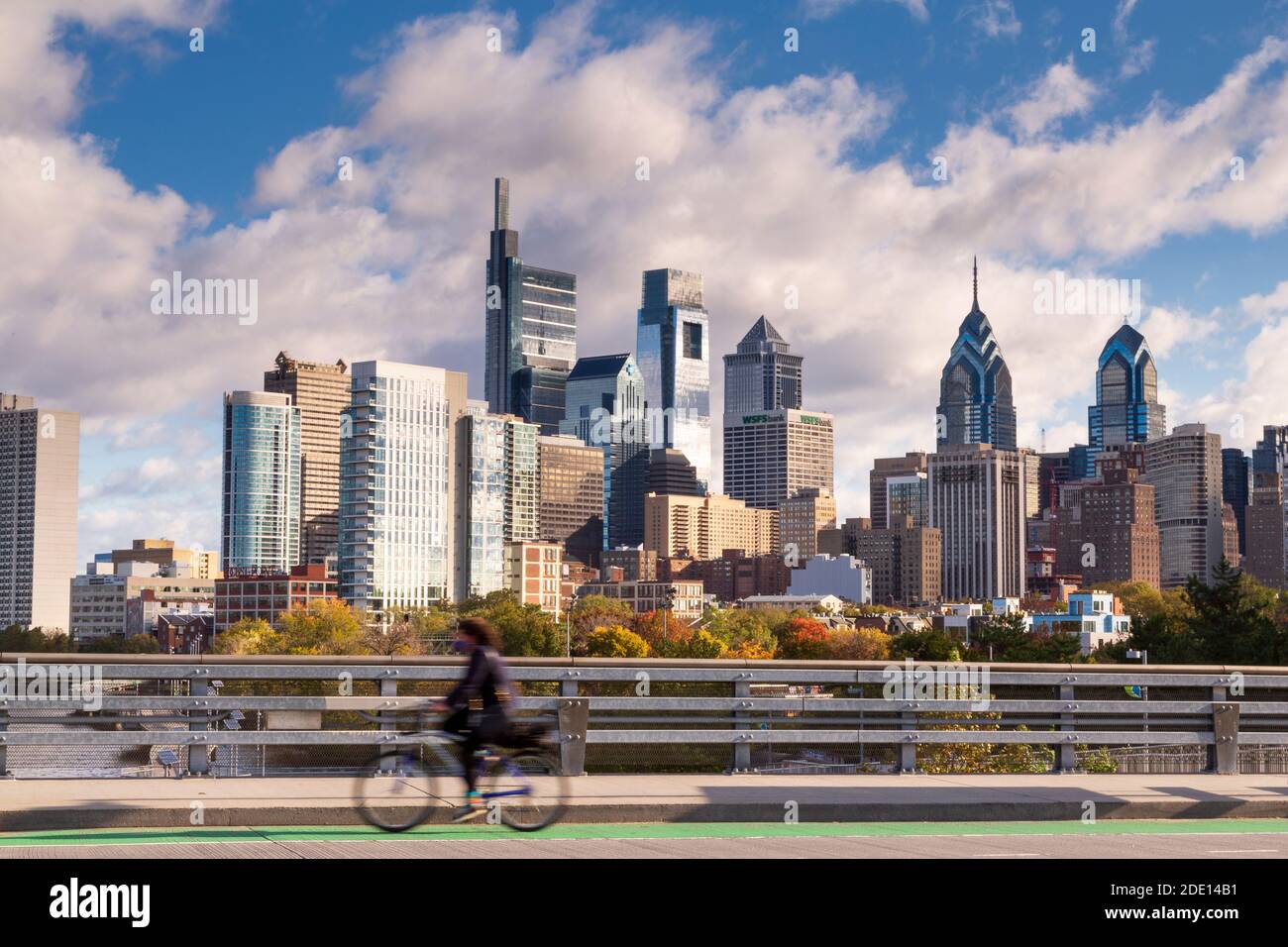 Skyline con ciclista en South Street Bridge yendo hacia University City, Filadelfia, Pensilvania, EE.UU Foto de stock