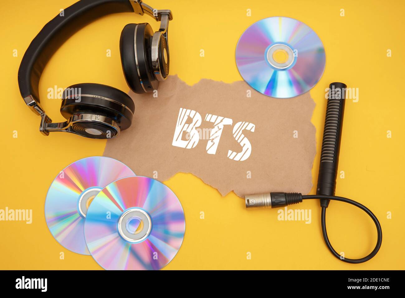 Concepto BTS con auriculares y discos de música sobre un fondo amarillo  Fotografía de stock - Alamy