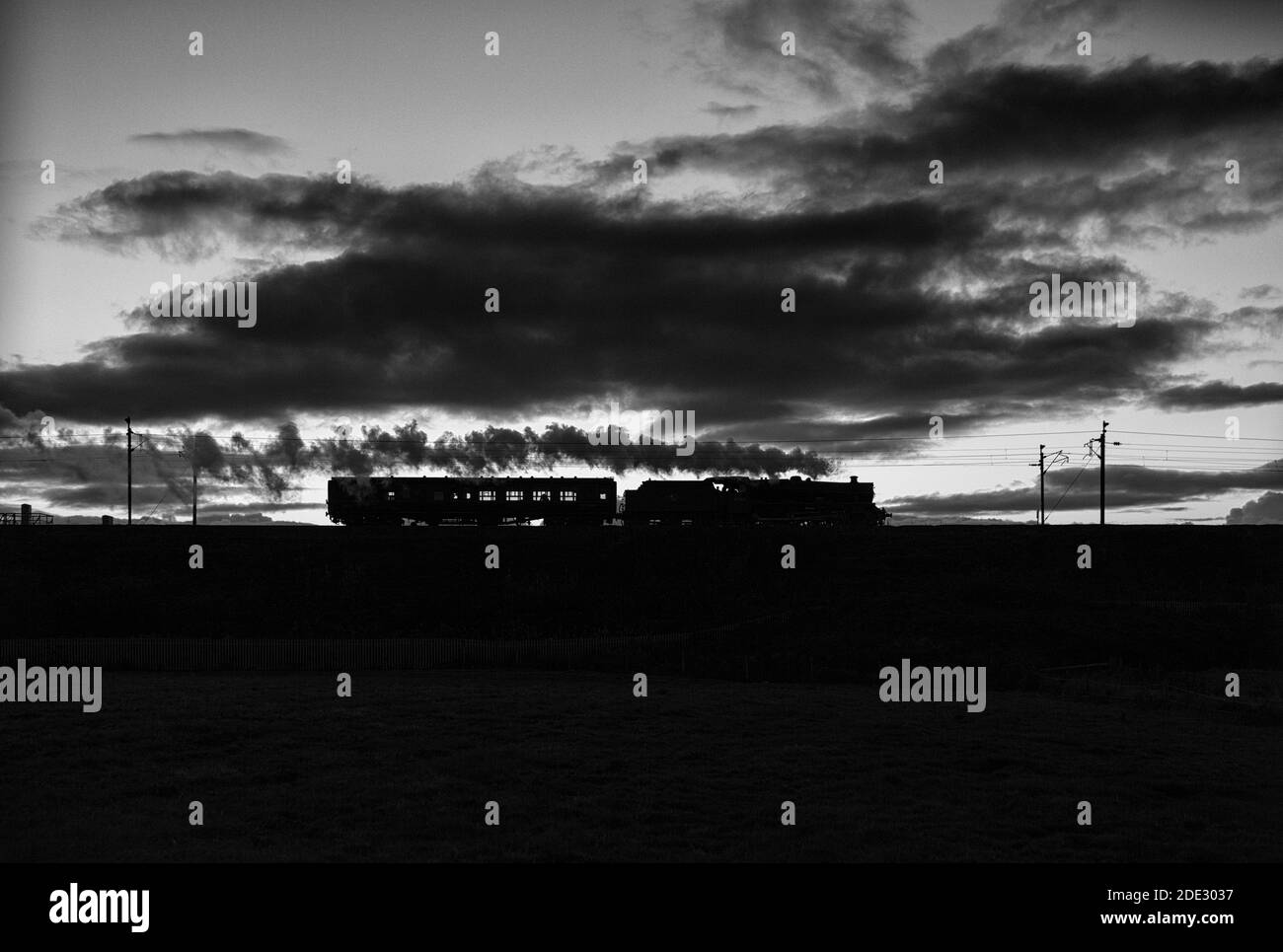Locomotora de vapor conservada 45699 'Galatea' en la línea principal de la costa oeste A la puesta de sol, regresando a Carnforth después de trabajar un vapor principal tren charter Foto de stock