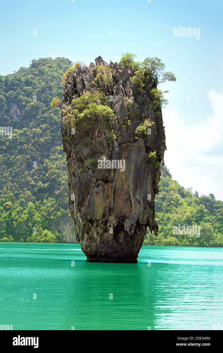 Isla de piedra con vegetación en el mar Foto de stock