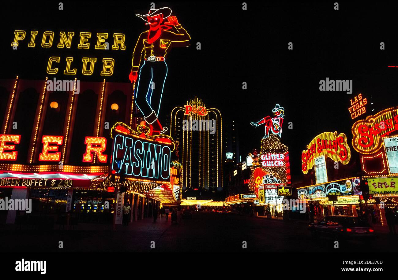 Las luces de neón y otras luces coloridas hicieron que estas señales al aire libre para casinos y hoteles se destacara por la noche y durante el día a lo largo de Fremont Street, el centro original para jugar y buenos momentos en las Vegas, Nevada, Estados Unidos. Fácilmente reconocido en la pantalla de neón son un vaquero y una vaquera apodada Vegas Vic y Vegas Vickie. Desde que esta fotografía histórica fue tomada en 1983, Fremont St. Ha sido cubierta con un dosel que es la pantalla de vídeo más larga del mundo y presenta un espectáculo de luz y sonido en el techo a los visitantes en la calle peatonal de abajo. Foto de stock