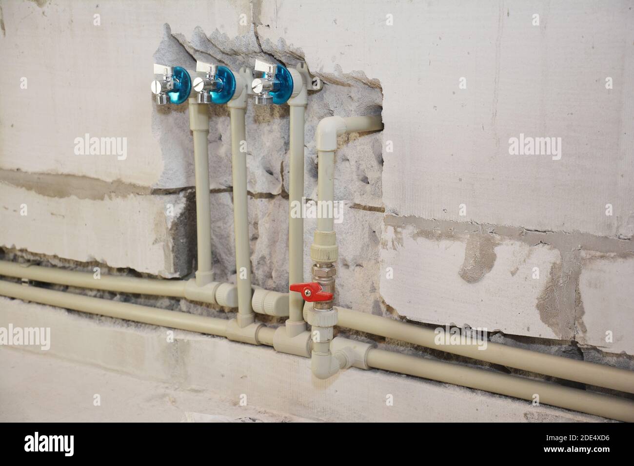 Instalación y ocultación en las tuberías de agua de la pared en el cuarto  de baño de la casa. Corte de ranura o trinchera para tuberías de agua  Fotografía de stock -