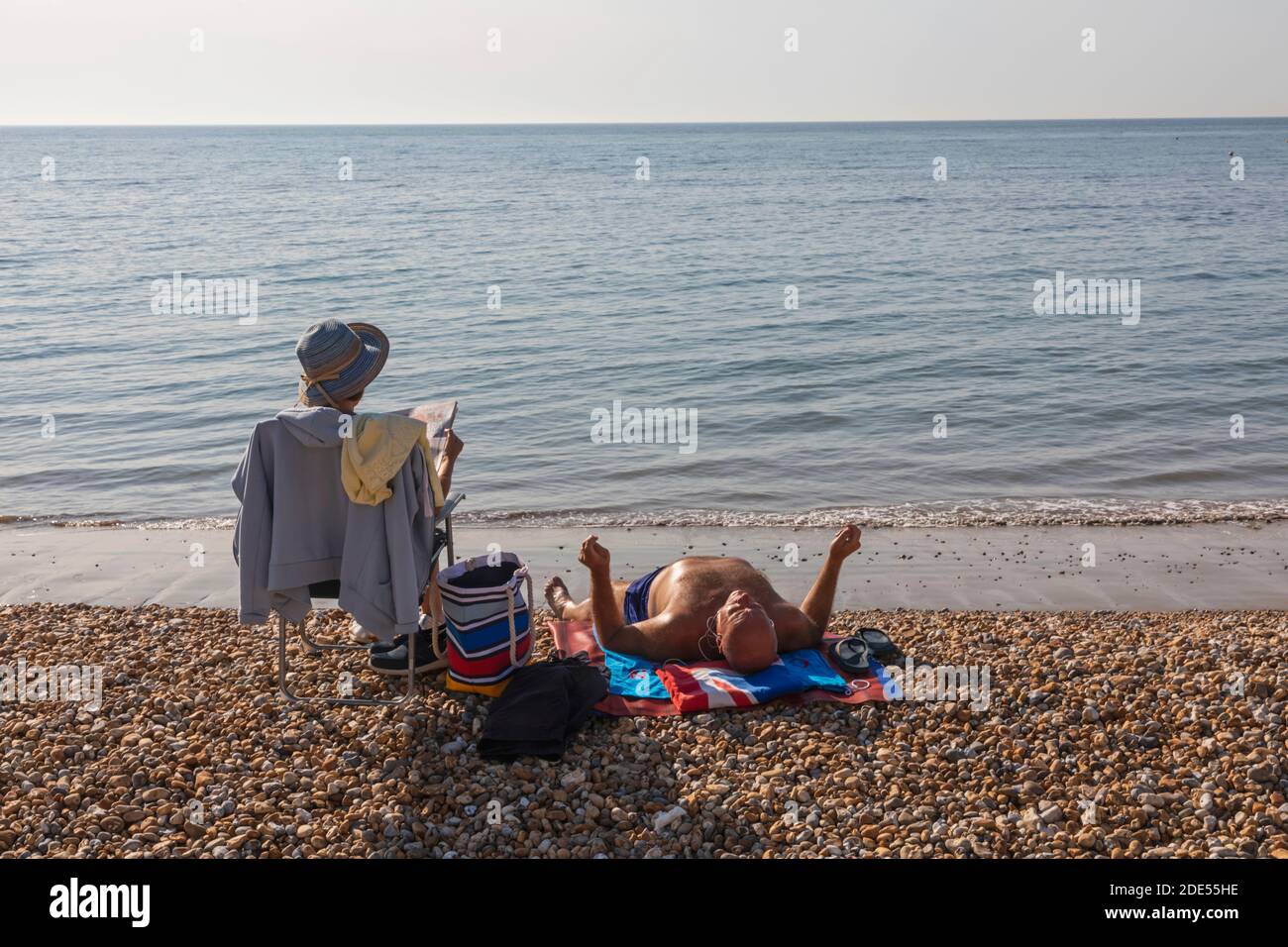 Inglaterra, West Sussex, Worthing, Worthing Beach, parejas mayores tomando el sol en la playa Foto de stock