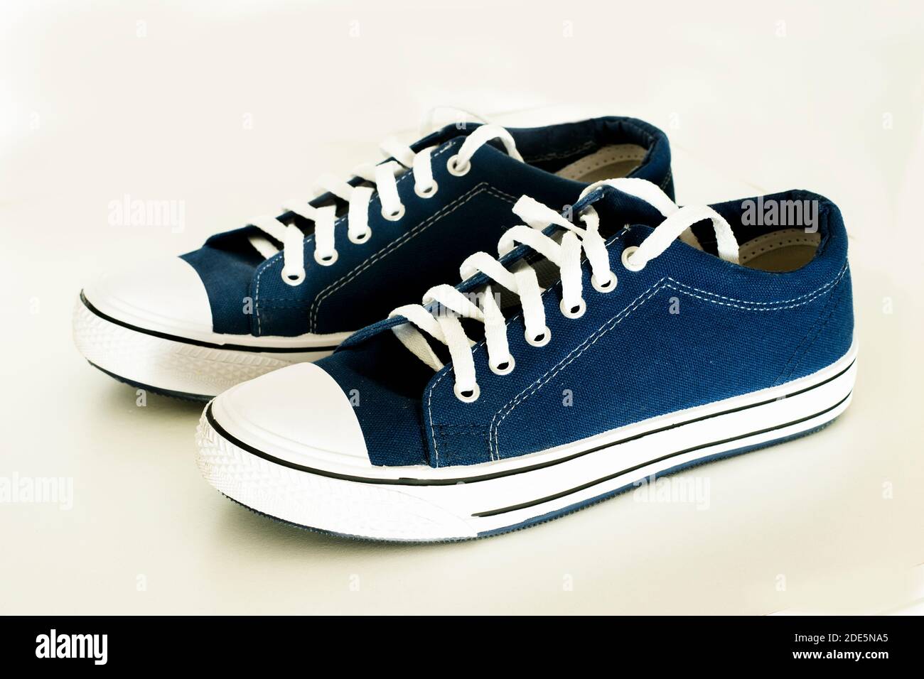 Un par de zapatos de tela azul sobre un fondo blanco.zapatillas de verano  Fotografía de stock - Alamy