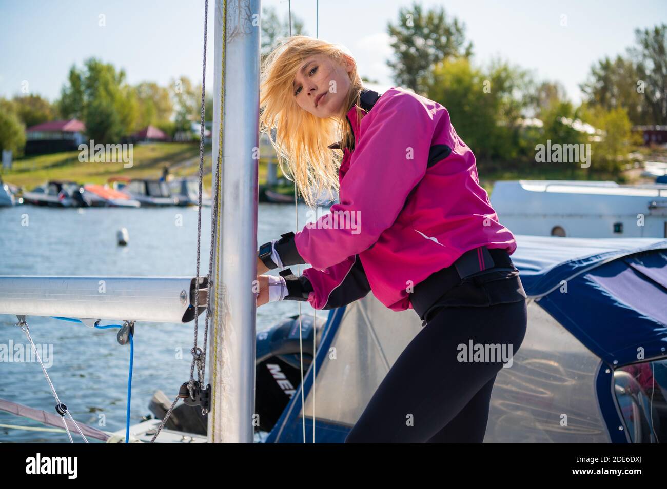 Niña atlética en ropa deportiva en un yate en el muelle está listo para una  regata de vela Fotografía de stock - Alamy