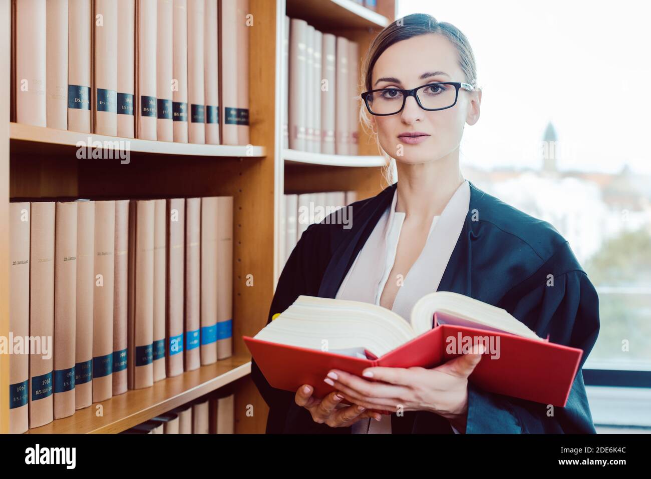 Abogado trabajando en un caso difícil de leer en la biblioteca Foto de stock