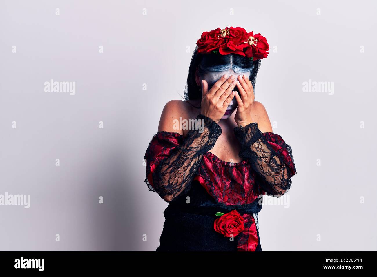 Mujer joven que llevaba el día mexicano de la muerte maquillaje con  expresión triste que cubre cara con manos mientras llora. Concepto de  depresión Fotografía de stock - Alamy