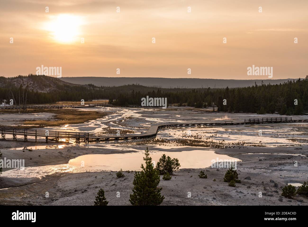 Una puesta de sol enmovada sobre la Cuenca de Porcelana en la Cuenca del Geyser Norris en el Parque Nacional Yellowstone, Wyoming, EE.UU. Foto de stock