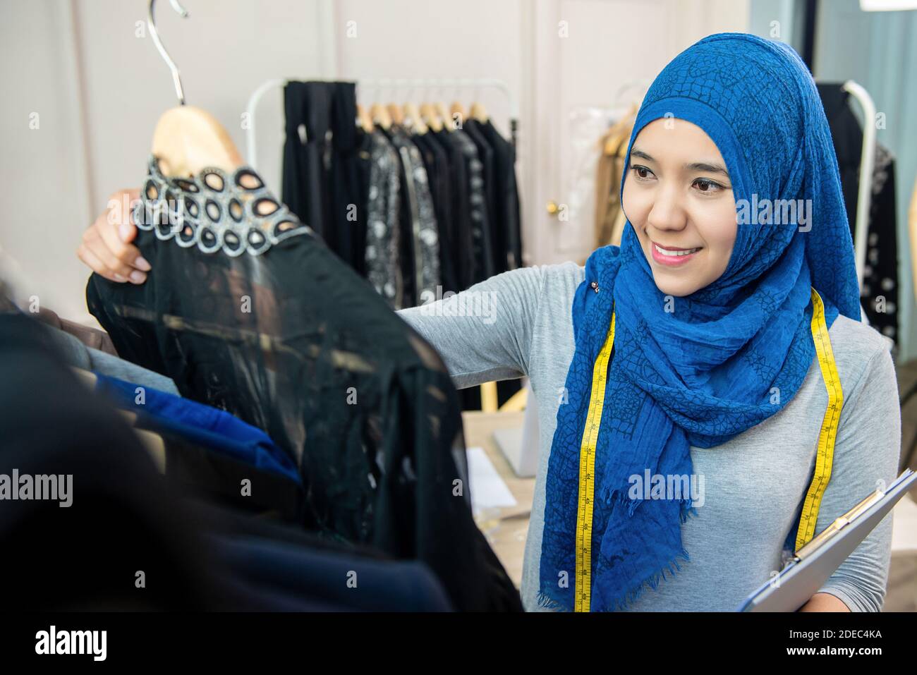 Mujer musulmana asiática diseñadora como propietario de un negocio de inicio que trabaja en su tienda de sastre Foto de stock