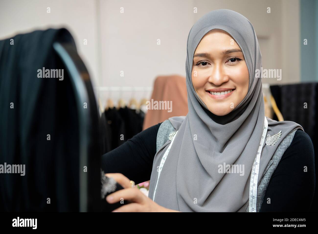 Mujer musulmana asiática diseñadora como propietario de un negocio de inicio que trabaja en su tienda de sastre Foto de stock
