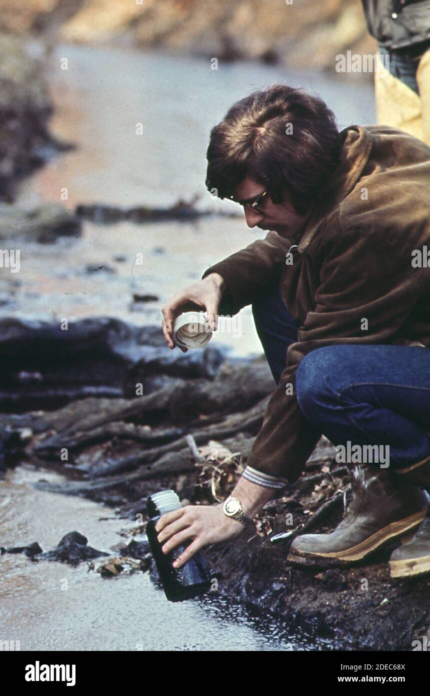 Don Miller; de la administración de recursos hídricos de Maryland; revisa el agua de Stony Run después de un derrame accidental de 4000 galones de aceite ca. 1973 Foto de stock