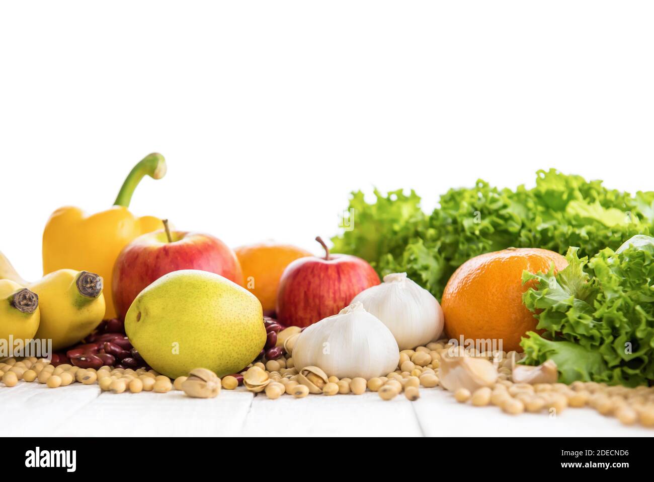 Varios tipos de frutas, verduras, frutos secos y especias saludables en la mesa de madera blanca Foto de stock