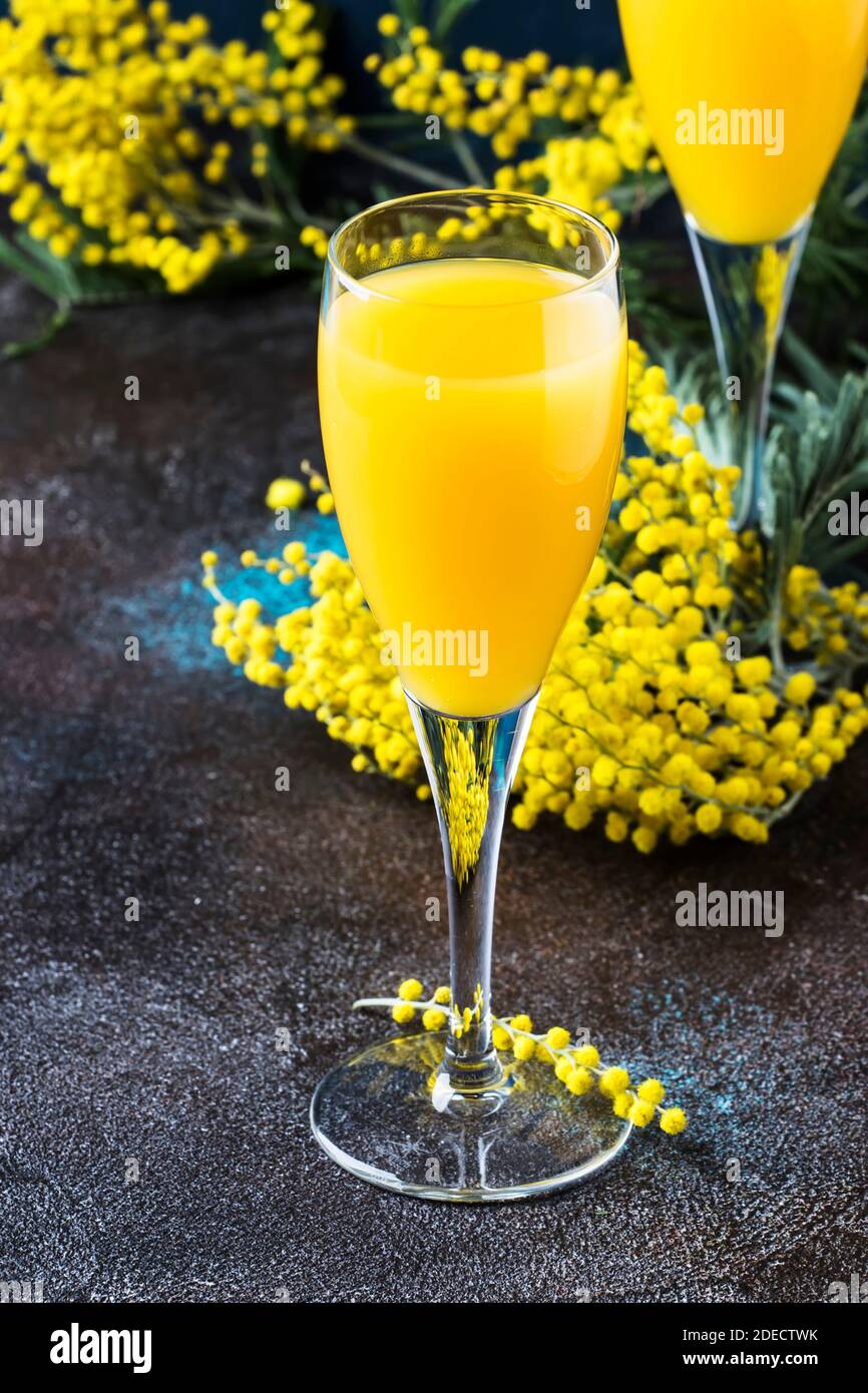 Cóctel bajo en alcohol mimosa con jugo de naranja y champagne seco frío o  vino espumoso en copas, fondo azul con flores, lugar para texto, selec  Fotografía de stock - Alamy
