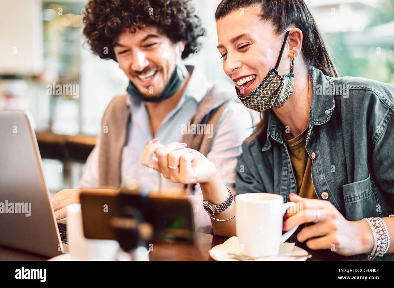 Jóvenes influencers mileniales compartiendo contenido creativo en la plataforma de streaming - Concepto de marketing moderno con pareja de próxima generación que se divierte Foto de stock