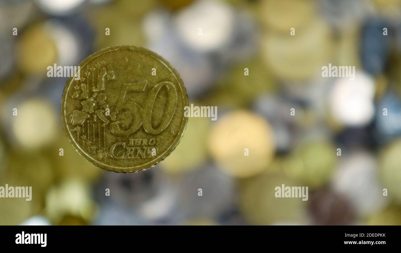 Un primer plano muestra una moneda de 50 céntimos de euro. Esto es dinero.  Fondo de dinero borroso. Moneda cambiable en la zona euro por valor de 0.5  euros. La moneda está