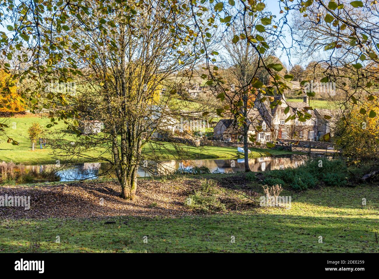 Otoño en los Cotswolds - el pequeño lago en el arroyo detrás de Manor Farm en Middle Duntisbourne, Gloucestershire Reino Unido Foto de stock