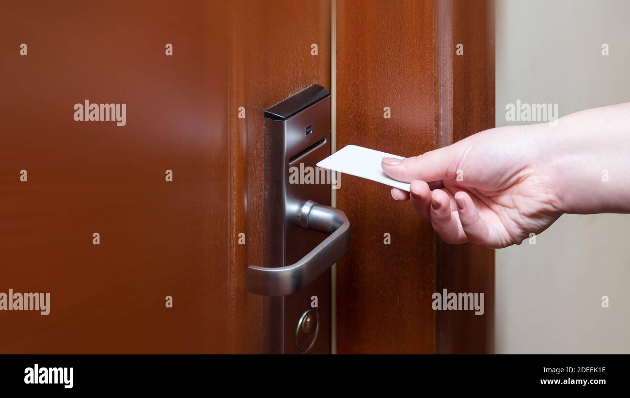 Lado femenino poniendo el interruptor en la tarjeta-llave para abrir la  puerta de la habitación del hotel. Sosteniendo la tarjeta magnética para  análisis de control de puertas de acceso tarjeta-llave para bloquear