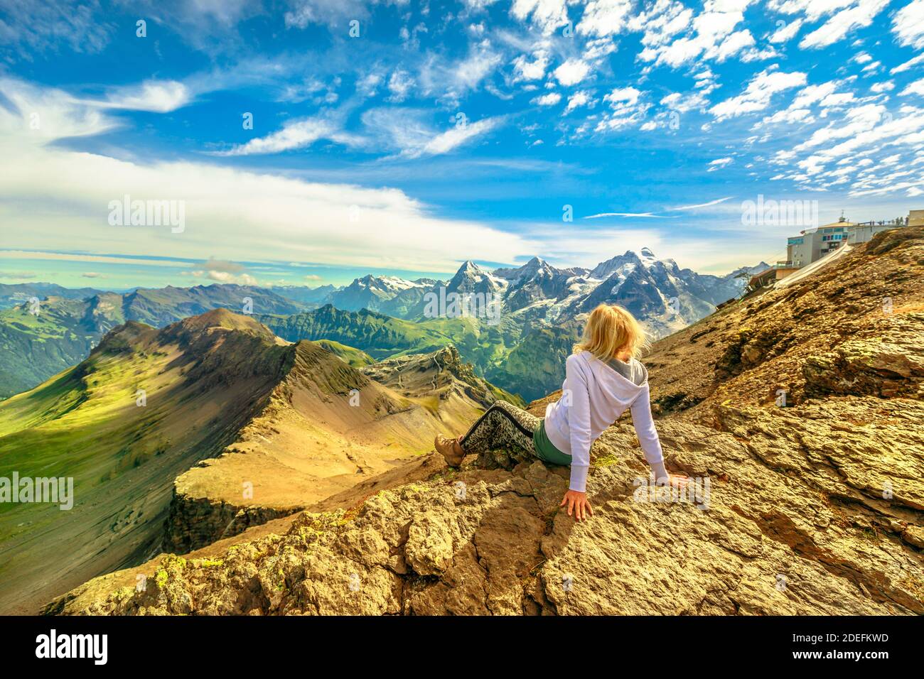 Mujer turística después de hacer senderismo, mirando el increíble panorama 360 grados que rodea 200 picos y Eiger, Monch y Jungfrau picos desde el punto de vista Schilthorn Foto de stock