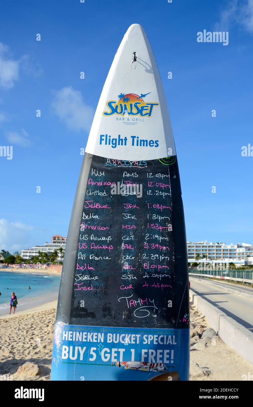 Llegada de aviones a la tabla de surf de Sunset Beach Bar en Maho Beach, St Maarten. Horarios de aterrizaje de aviones, una atracción turística en San Martín. Foto de stock