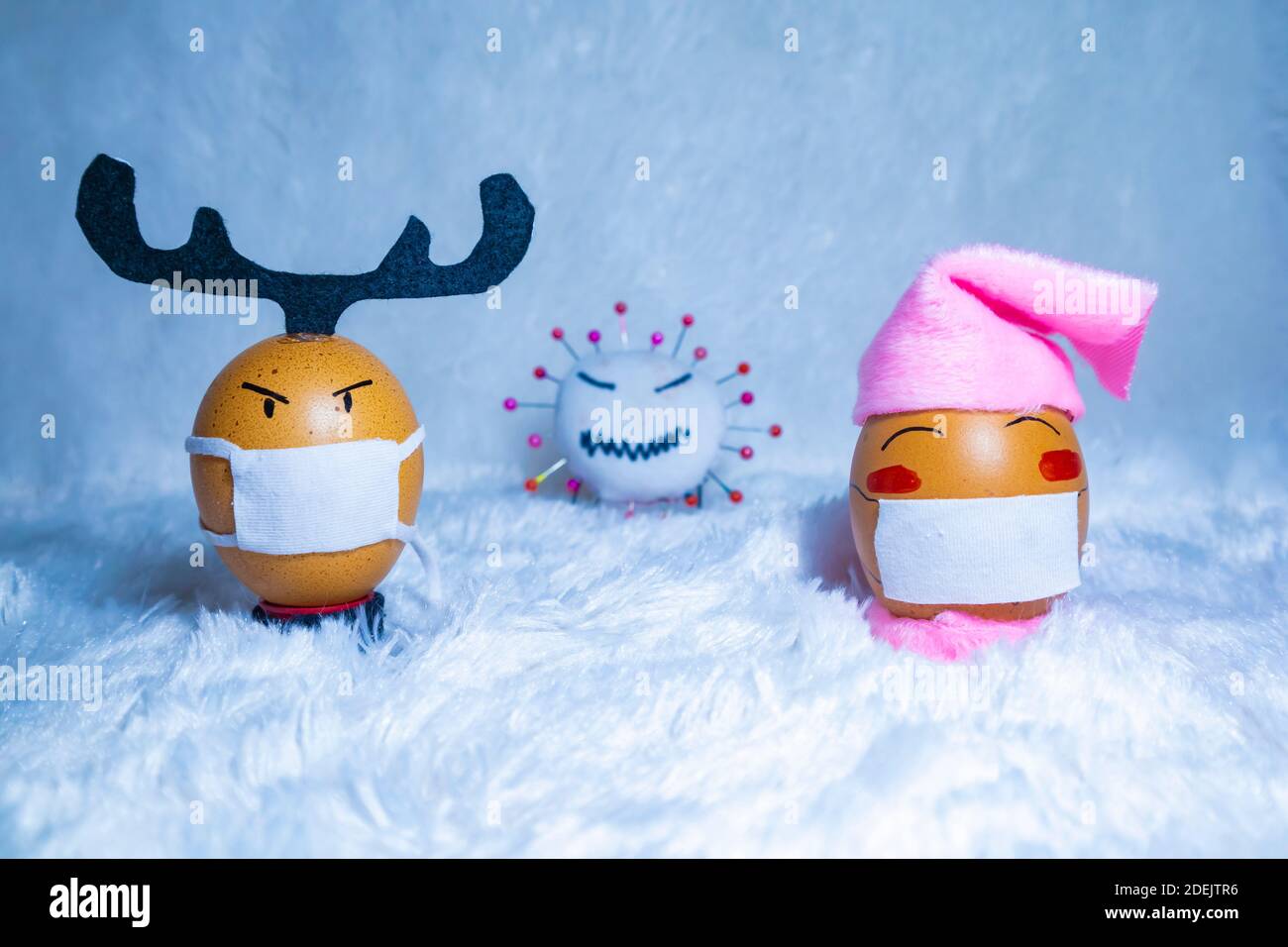Lindos huevos pintados con muñeca virus corona para celebrar la Navidad en tiempos de covid pandemia. Actividades divertidas en el interior con los niños. Foto de stock