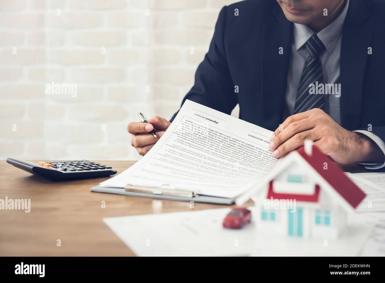 El empresario como agente inmobiliario o inversionista calcular el crecimiento de la rentabilidad de la inversión en bienes raíces antes de firmar el contrato en la oficina Foto de stock