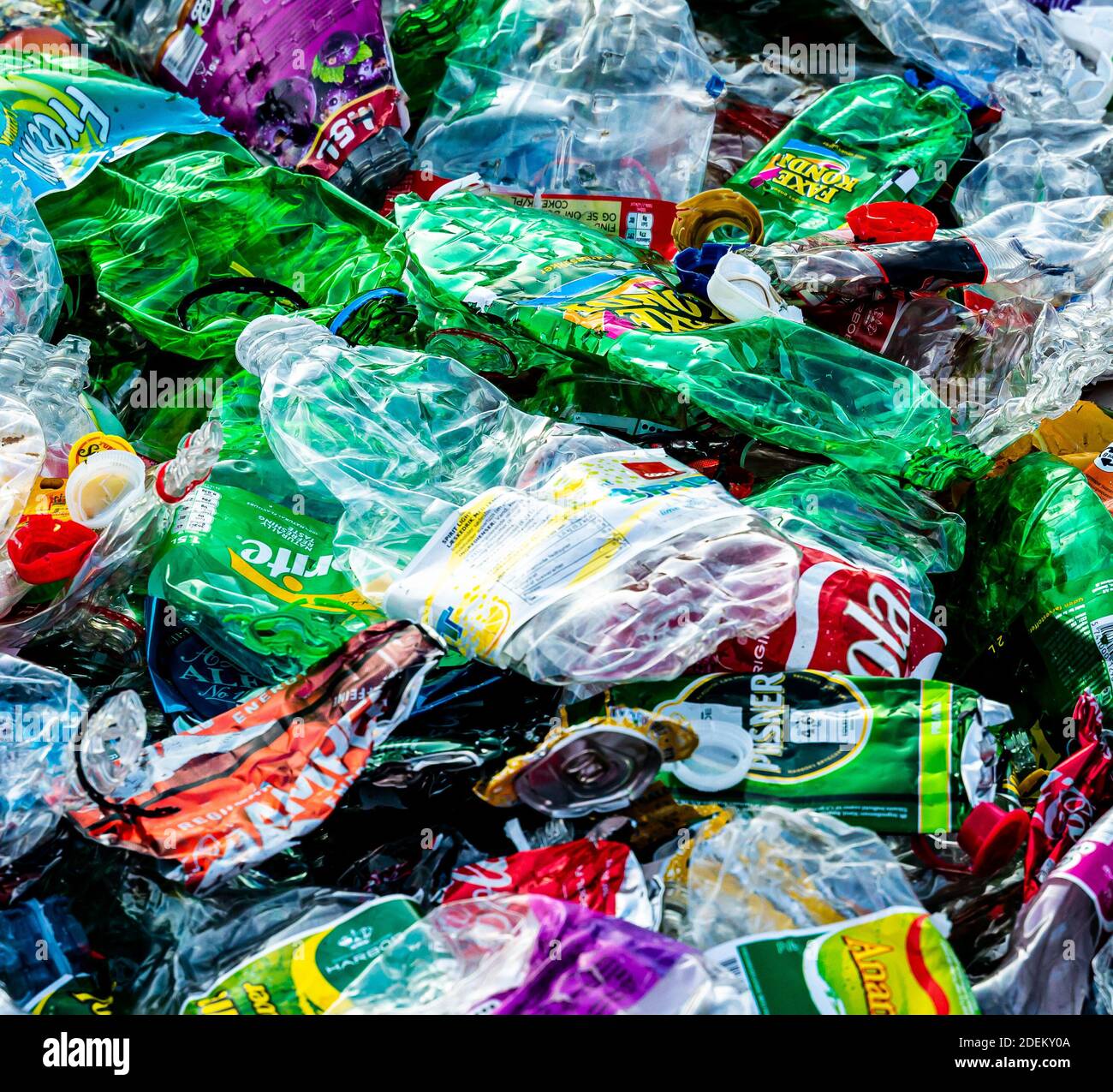 Botellas de plástico usadas y trituradas y latas de aluminio listas para la planta de reciclaje. Foto de alta calidad Foto de stock