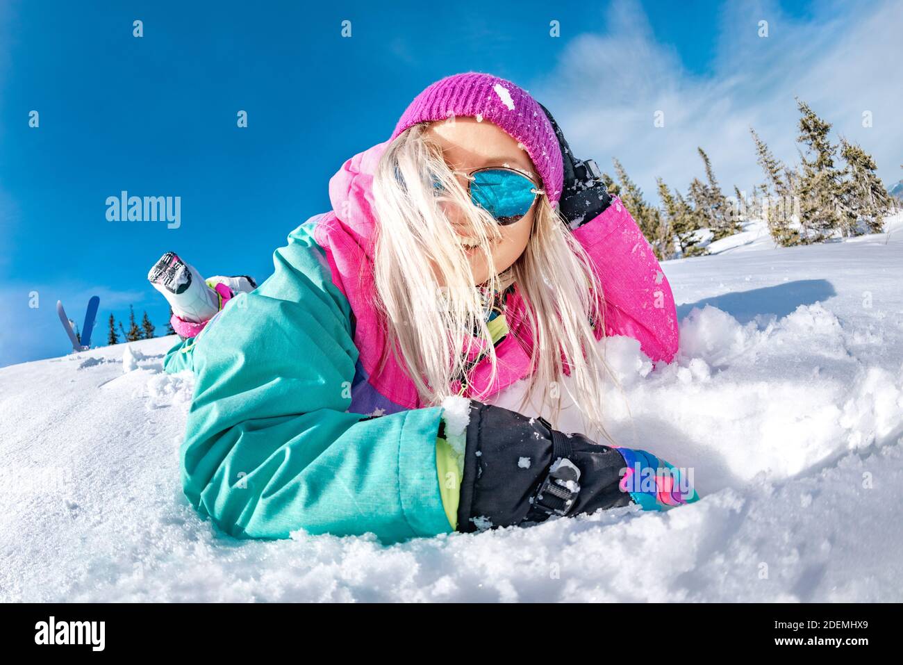 Feliz chica snowboarder en colorido ropa de se encuentra en polvo de nieve y la Concepto de estación de esquí Fotografía de stock - Alamy
