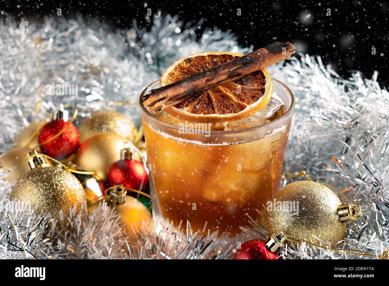 Cóctel especial de Navidad servido sobre hielo en un vaso de roca Con decoraciones navideñas Foto de stock