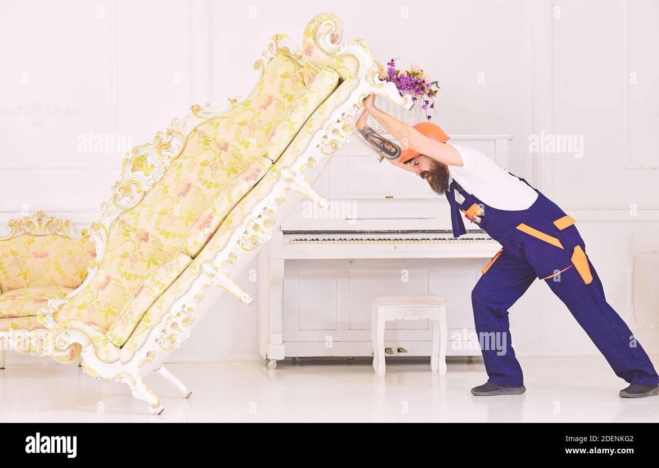 Concepto de servicio de entrega. El cargador mueve el sofá, el sofá