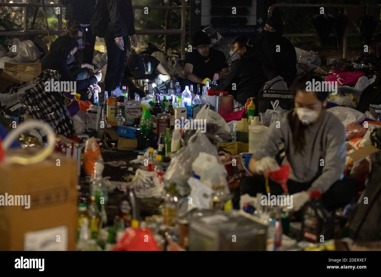 Estudiantes preparando cócteles molotov temprano en la mañana en el campus escolar para la próxima batalla de guardia contra la policía en Hong Kong el 13 de noviembre de 2019. Batallas sin precedentes en la Universidad China de Hong Kong (CUHK). Hong Kong protesta continua en sus cinco meses. El lunes 11 de noviembre de 2019 se inició una huelga en toda la ciudad, que detuvo a partes de Hong Kong, ya que las estaciones de MTR cerraron y se levantaron múltiples barricadas. Donde también está bloqueada la autopista Tolo Harbour bajo el puente no.2 que conecta la Universidad China de Hong Kong (CUHK) con el espacio público. Foto de May Ja Foto de stock