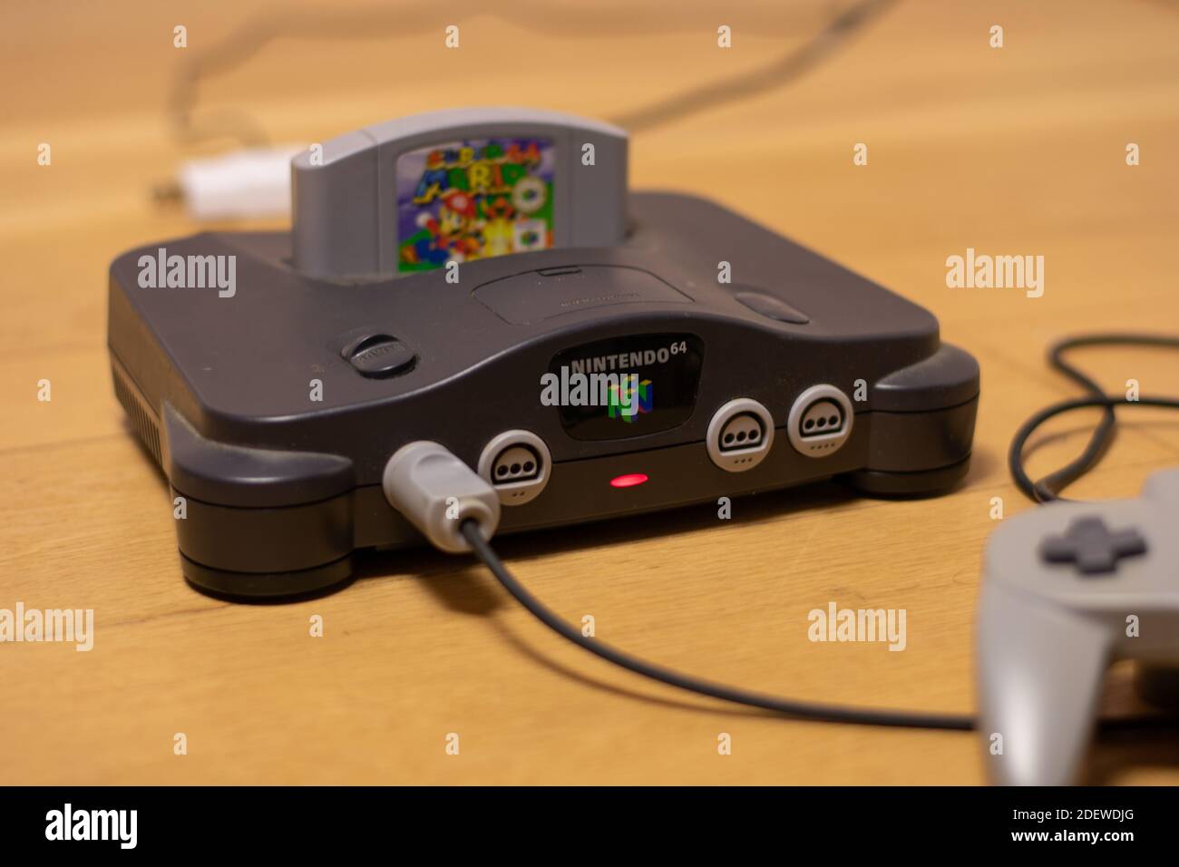 Una consola Nintendo 64 con la luz indicadora de alimentación encendida Y Super  Mario 64 en la ranura de cartucho y un Controlador conectado a IT  Fotografía de stock - Alamy