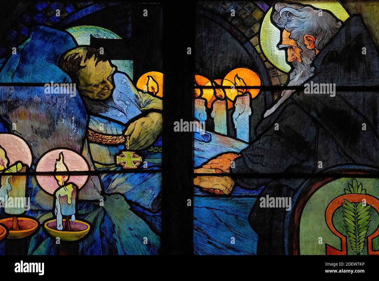 Vigilia a la luz de las velas en el lecho del teólogo bizantino y misionero San Cirilo, representada por el influyente artista Art Nouveau Alphonse Mucha en su vívida vidriera de 1930 para la Capilla del Nuevo Arzobispo en la Catedral de San Vito en Praga, capital de la República Checa / República Checa. La obra de arte, una alegoría de Cristo que bendice a las naciones eslavas, presenta escenas de la vida de los ‘Apóstoles a los eslavos’ Cirilo y su hermano Metodio, así como el patrón checo san Wenceslao, duque de Bohemia, y su abuela, San Ludmila. Foto de stock