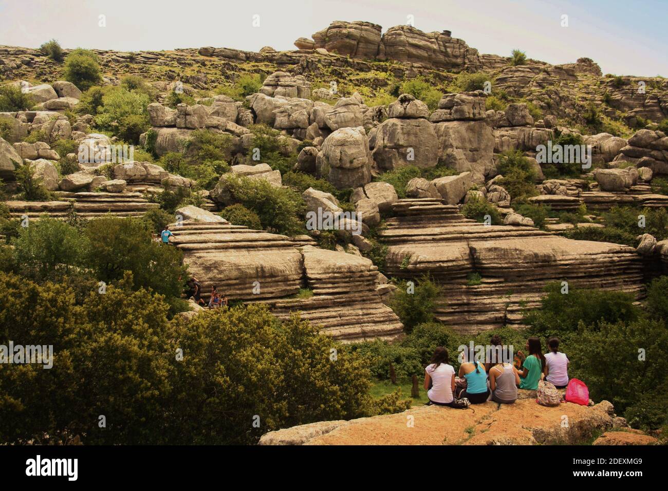 Antequera, España - 8 de mayo de 2015: Paisaje kárstico prehistórico de el Torcal de Antequera con formación rocosa admirada por las escolares en el viaje de campo Foto de stock